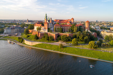 Royal Wawel Cathedral and castle in Krakow, Poland. Aerial view in sunset light. Vistula River with people on stand up puddles, riverbank with park. promenade and  walking people