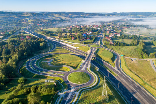 New highway junction in Poland on national road no 7, E77, called Zakopianka. Overpass crossroad with traffic circles, slip roads and viaducts near Rabka. Aerial view. Far view of Tatra Mountains