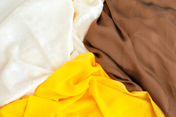 Silk fabric in three types. Textured background from multicolored silk fabric. Brown, white and...