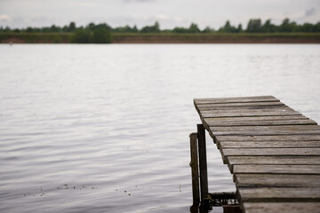 Closeup of a bridge on a river for fishing. Wooden pier for boats and yachts. Fishing on the lake.