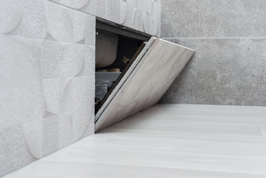 Open hidden revision sanitary hatch under the bathroom 
