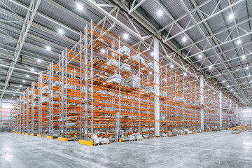 Large industrial warehouse. Tall racks are completely filled with boxes and containers.