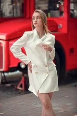 Foto op Plexiglas jonge vrouw in de buurt van Engelse bus. De rode bus van Londen - meisje dat van het leven geniet. portret van mooie vrouwelijke model dragen bij witte lange jaket. © Volodymyr Shcerbak
