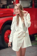 Foto op Plexiglas jonge vrouw in de buurt van Engelse bus. De rode bus van Londen - meisje dat van het leven geniet. portret van mooie vrouwelijke model dragen bij witte lange jaket. © Volodymyr Shcerbak