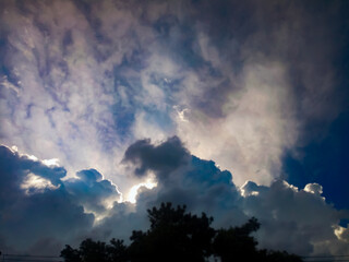 Obraz na płótnie Canvas Gray clouds covering the sun in the evening sky.