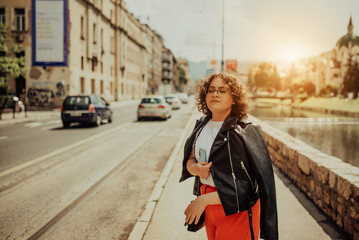 African woman glasses and modern clothes combination posing in modern city