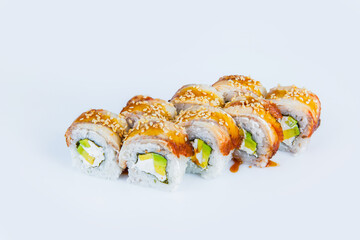Japanese Sushi Roll with avocado, Philadelphia cream cheese and eel on top. isolated on gray background. Served with Unagi sauce and sesame seeds seeds. Asian dish Menu isolation.
