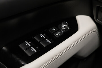 Interior of modern car. Side door buttons: window, mirror adjustment buttons, door lock. Car inside..