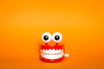 greeting card for Halloween. funny jaw with eyes on orange background. terrible smile with white teeth. minimal, copy space