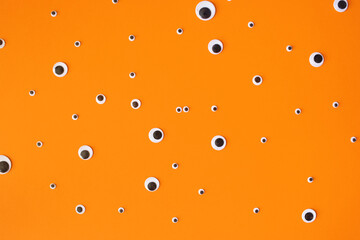 greeting card for Halloween. funny eyes on orange background. minimal