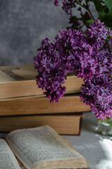 bouquet of lilacs on the table with books
