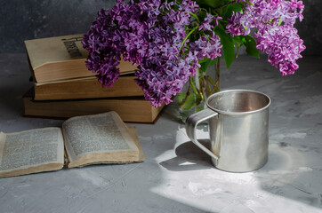 bouquet of lilacs on the table with books