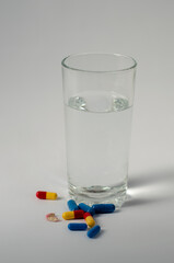 a glass of water with pills