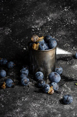 plums with snails on black background