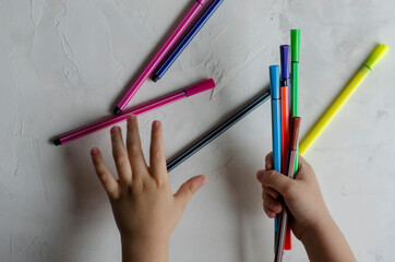 kids hands hold markers