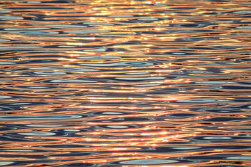 Beautiful colorful water surface with waves at sunset