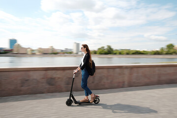 Young carefree female in casualwear and sunglasses moving on electric scooter © pressmaster