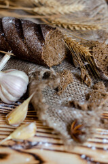 black bread on a wooden background with wheat ears