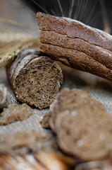 black bread on a wooden background with wheat ears