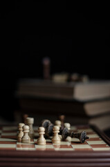 chess on the table next to a stack of books