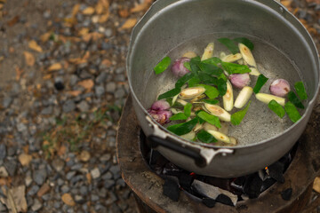 water with seasoning in the pot hold on charcoal stove