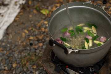 water with seasoning in the pot hold on charcoal stove