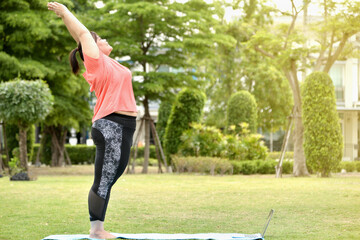 chubby happy woman exercise or yoga on green natural tropical garden at home for new normal...