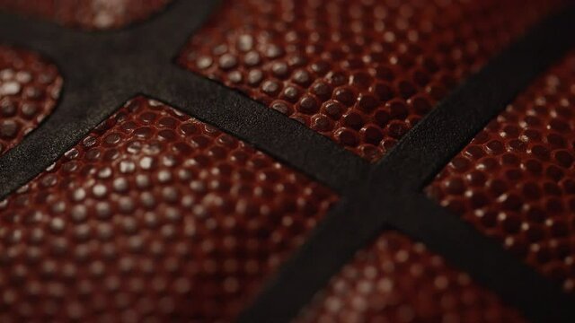 Focus pull across the surface of a basketball under dramatic lighting