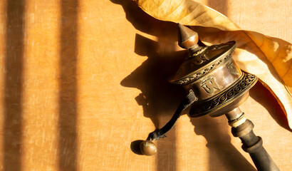 Worship equipment with initials of the prayer written on metal surface for Buddhist and a dry leaf...