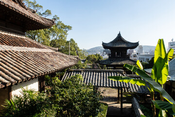 Obraz premium Wooden, carved decorated roofs of one of the oldest historic Zen Buddhist Temple Complex (Seifuku-ji) in Nagasaki with Nagasaki landscape, Japan.