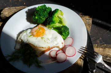 fresh broccoli with fried eggs on a wooden board