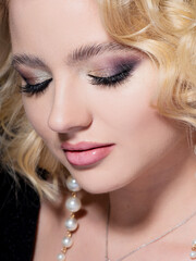 Gorgeous blonde, portrait on a black background. Beautiful young girl with stylish sexy make-up,