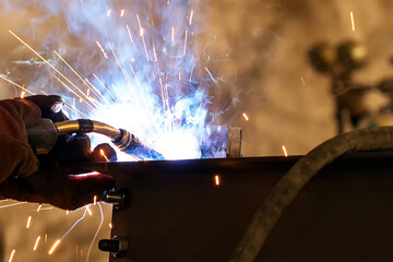 Close up view of the gas metal arc welding (GMAW), also known as metal inert gas or MIG welding. In...