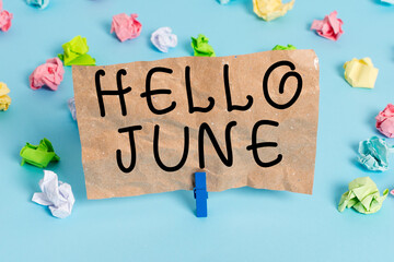 Text sign showing Hello June. Business photo text a new month to plan your activities for fun and adventures Colored crumpled papers empty reminder blue floor background clothespin