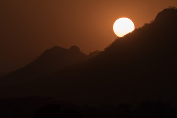 Magical close up shot of Sun setting down behind mountains