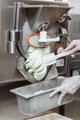 Pile of ready-made ice cream falling out of the freezer at the manufacturing, close-up