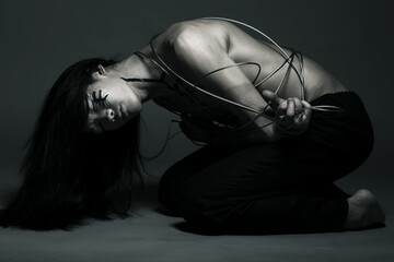 asian man with steel wire over dark background