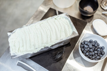 Chef making ice cream at the table with blue berries