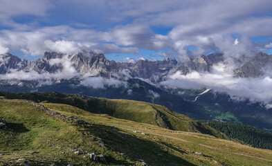 Scattered clouds above and below the Sesto Dolomites massif in Italy as seen from the Carnic Peace Trail along the Carnic Alps on the way up the Hornisch Eck summit, Carnic Highroute trek, Austria.