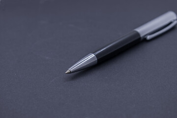ballpoint pen centered on a dark background