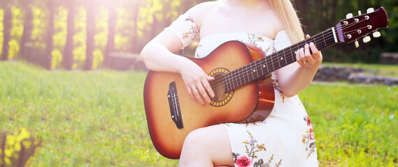 Beautiful girl and retro guitar in the garden
