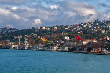 Naklejka na ściany i meble photo of the Bosphorus shore with a mosque and a Turkish flag