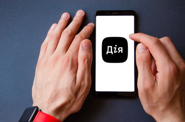 A male hand holds a smartphone, points a finger, types. Communication on a smartphone, correspondence. Place for text. Smartphone in hand on a gray  background.