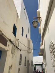 Asilah, Morocco-August 04 2019: Narrow old street in the medina of Asilah with tourists