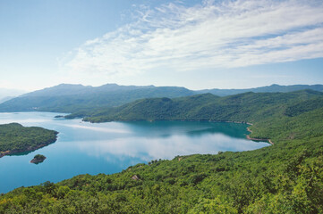 Fototapeta na wymiar Picturesque blue lake among green mountains. Montenegro, Niksic, view of the Salt Lake