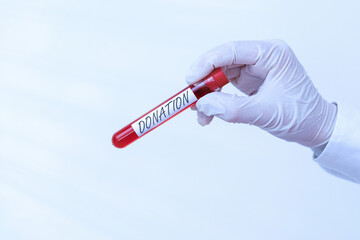 Obraz premium Writing note showing Donation. Business concept for something that is given to a charity, especially a sum of money Extracted blood sample vial ready for medical diagnostic examination