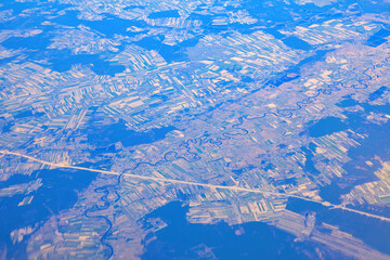 Aerial view of river meander and plains . Panoramic view of river and highway . View from airplane window . Flying over Poland 