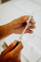 
ampoules and needles on a tablet in a hospital, preparation of needles to be filled with medicine, close up of hands preparing a needle with medication