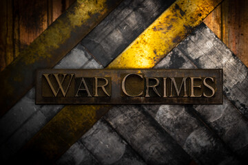 War Crimes text formed with real authentic typeset letters on vintage textured silver grunge copper and gold background