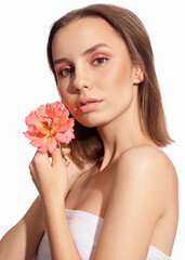 Young beautiful woman with pink flower on white isolated background. Woman with natural make up.